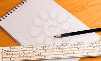 Pencil ruler and notebook on a wooden background