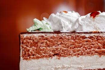 Piece of sweet layered cake closeup on a dark background
