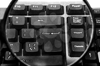 Computer keyboard with magnifying glass close up