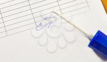 A corrector brush and a colored false signature on a piece of paper