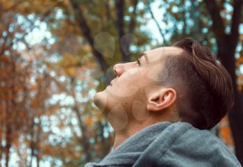 A dreamy young man in an autumn park
