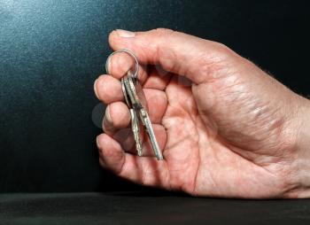 Hand with keys on a dark background
