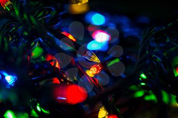 Background of colored lights garlands in the dark