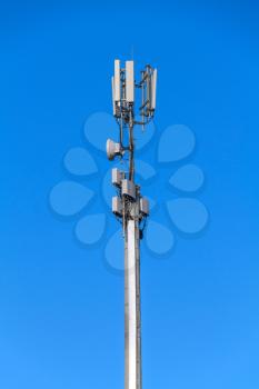 Tower with antennas of cellular communication on blue sky background