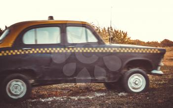 Stylized photo of a very old taxi in motion on a cloudy day