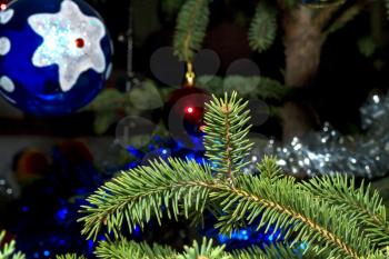 Spruce branch with ball and tinsel close up