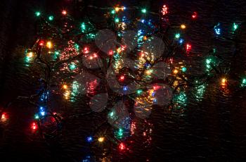 Multi-colored lights on a dark background on a reflective surface