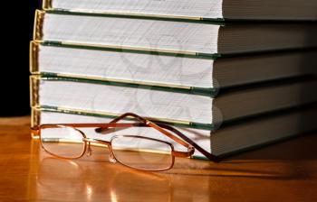 Glasses and a stack of books on the table