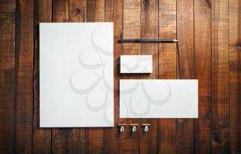 Photo of blank stationery set on wood background. Blank stationery and corporate identity template. Blank letterhead, business cards, envelope and pencil. Top view.