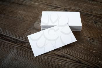 Photo of blank business cards on dark wooden background. Template for ID. Mock-up for branding identity.
