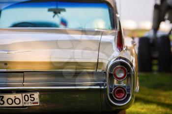 MINSK, BELARUS - MAY 07, 2016: Close-up photo of beige Cadillac de Ville 1959 model year. Back view of retro classic vintage car. Shallow depth of field. Selective focus.