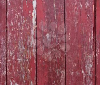 Old wooden planks with peeling red paint.