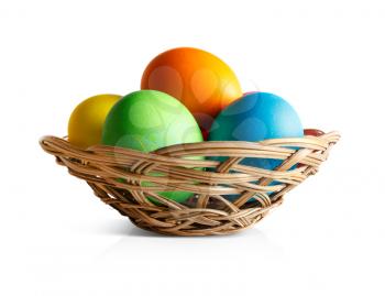 Easter eggs in a wicker basket. White background.