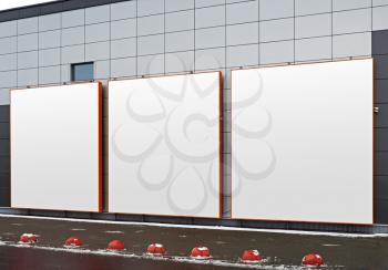 Three blank square advertising space on the facade of a modern building. Isolated on white with clipping path.