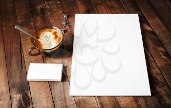 Blank paper, letterhead, coffee cup and business cards. Blank paperwork template. Blank stationery set on vintage wooden table background. Mock-up for design portfolios.