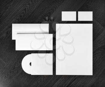 Blank stationery and corporate identity template on dark wooden background.  For design presentations and portfolios. Top view. 