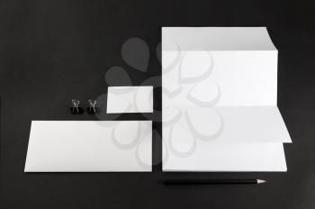 Photo of blank stationery set on black background. Template for branding identity for designers. Top view.