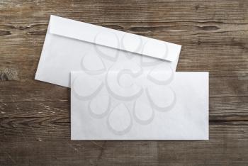 Photo of blank envelopes on a dark wooden background. Back and front view. Template for ID. Top view.