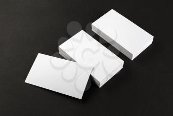 Photo of blank business cards on a black background. Template for branding identity. Top view. Shallow depth of field.