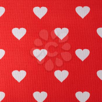 Hearts pattern on red fabric texture background.