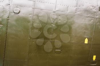 Abstract military green metal background texture with seams and rivets.