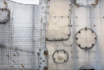 Abstract vintage silver metal background with rivets and bolts. Part of the shell plating of the old aircraft.