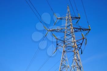 Electricity transmission pylon against blue sky. High voltage tower.