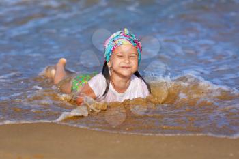 Happy child girl play and having fun in the water at the beach. Selective focus.