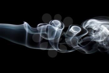 Photo of abstract light smoke swirls on black background. Studio shot.