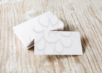 Photo of blank business cards with soft shadow on light wooden background. Blank template for your design.