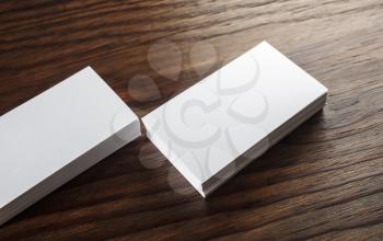 Close-up of blank white business cards on wooden table. Blank template for design presentations and portfolios. Mock-up for ID.