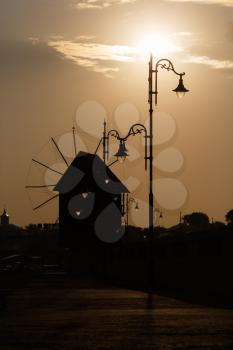 Silhouette of windmills and streetlights at daybreak. Shallow depth of field.
