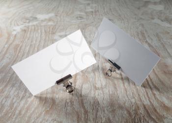 Photo of blank business cards with soft shadow on light wooden background. Template for graphic designers portfolios.