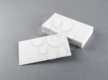 Photo of blank business cards with soft shadows on gray background. For design presentations and portfolios. Mock-up for branding identity.