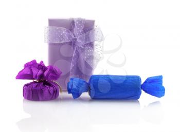 Three bright colorful gift boxes on a white background with reflection. Isolated with clipping path.