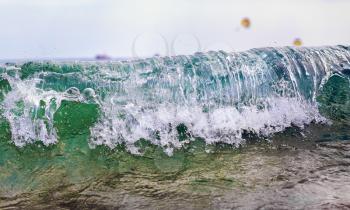 Wave with splashes closeup. Shallow depth of field.