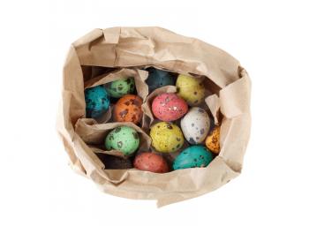 Colored quail eggs in a paper bag on a white background. Isolated with clipping path Top view.