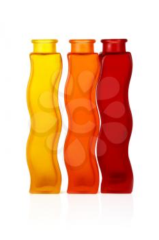Three bottles of colored glass on a white background. Clipping path.