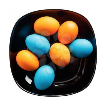 Colored Easter eggs on a black plate. Isolated with clipping path. Top view.