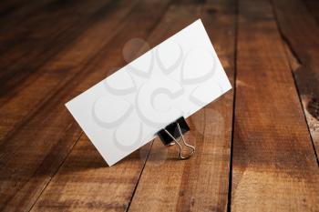 Photo of blank business card on vintage wood table background. Mock-up for ID. Blank template for branding identity for designers.