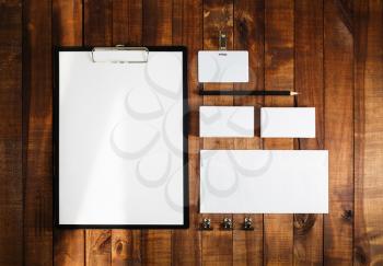 Blank business brand template on wooden table background. Blank stationery set on wooden table background. Letterhead, business cards, badge, envelope and pencil. Top view.