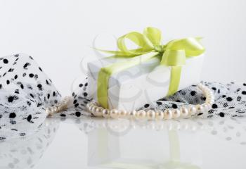 Still life with gift box, pearl beads and fabrics.