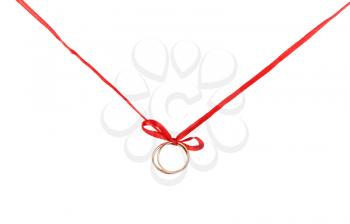 Wedding rings on a red ribbon with a bow. Isolated on white background.