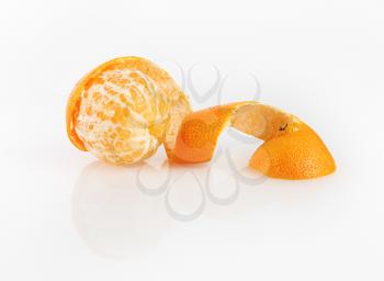 Delicious juicy clementine. Peeled tangerine on a light background.