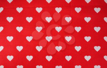 Hearts pattern on red fabric texture background.