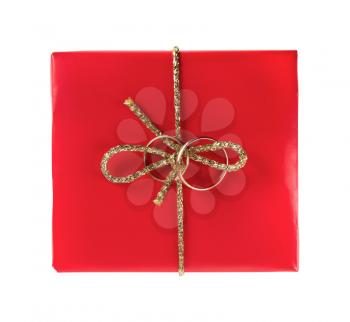 Red gift box with wedding rings on a white background. Isolated with clipping path. Top view.