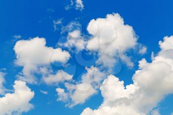 Blue sky with white cumulus clouds on a bright sunny summer day