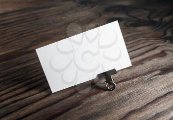 Blank white business card on dark brown wooden background. Mockup for branding identity. Blank template for graphic designers portfolios.