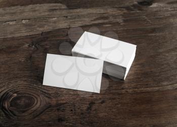 Blank white business cards on dark wooden background. Mockup for branding identity for designers.
