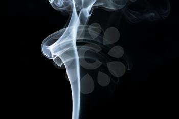 Photo of abstract smoke swirls over black background.